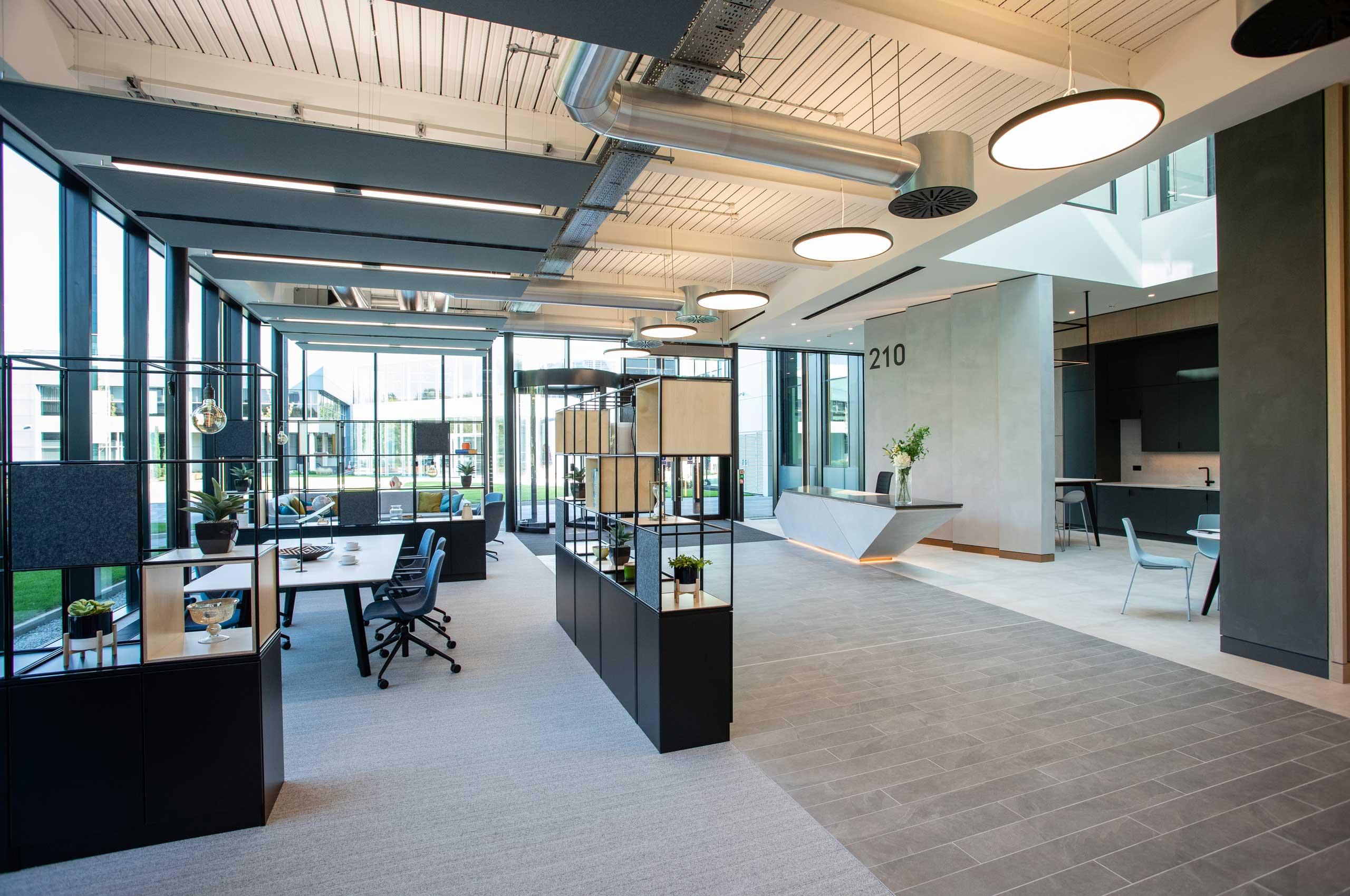 Commercial office reception fit-out with lighting feature, reception desk, and meeting pods.